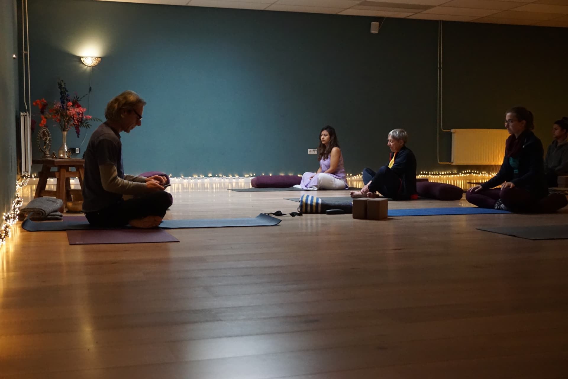 Zittende meditatie bij kaarslicht in de studio van Yogapoint Nijmegen