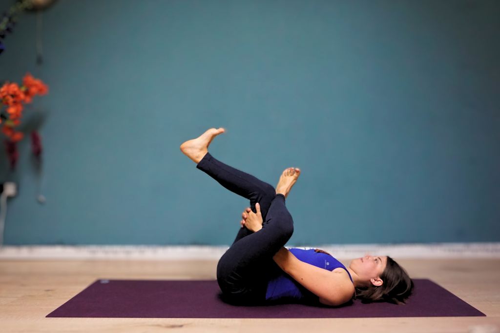 Liggende yogahouding op een paarse mat in de studio van Yogapoint Nijmegen